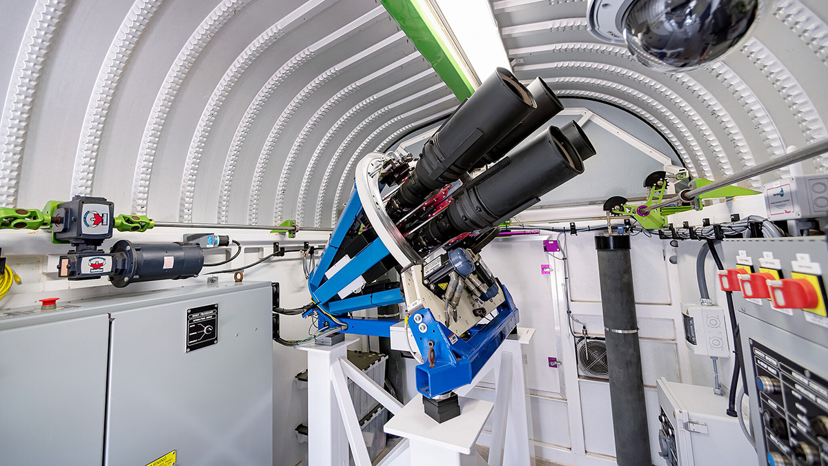 A telescope pointed up to the right in an observatory