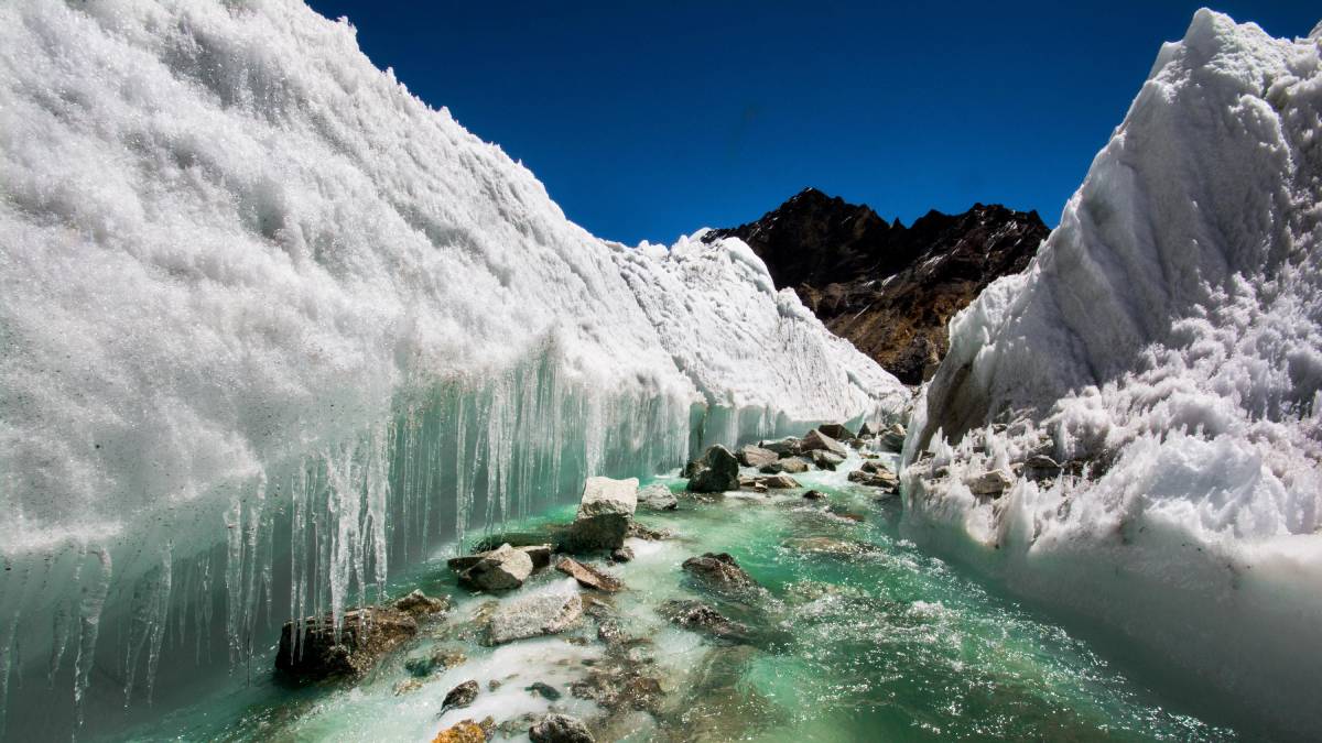 Water carving through ice in a mountain area.