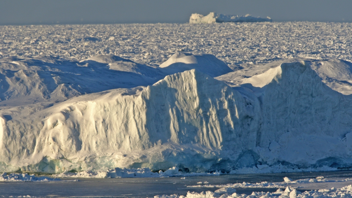 A large iceberg floats in the sea.