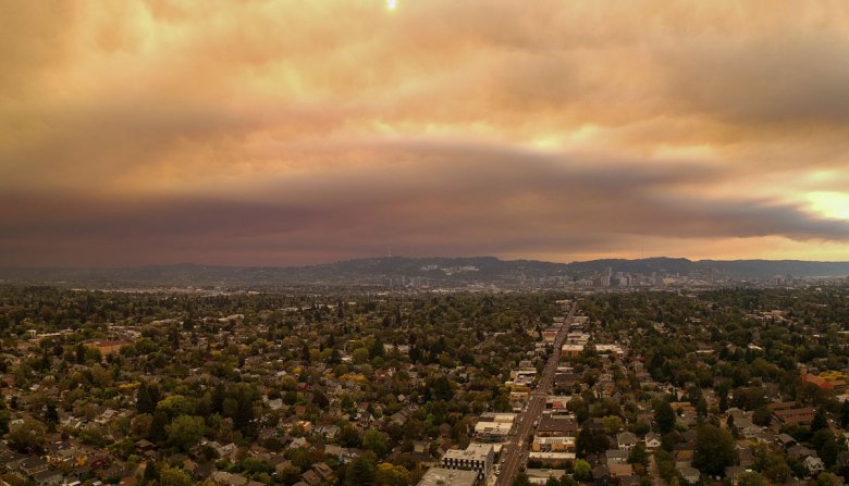 Orange-tinted smoke and clouds hang low over the landscape of Portland, Ore.