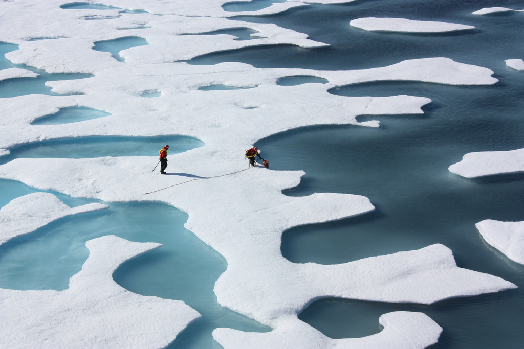 Scientists stand atop Arctic ice.