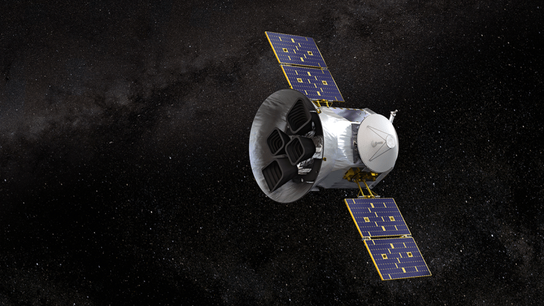 A barrel-shaped space telescope with solar array “wings” looks into starry space.