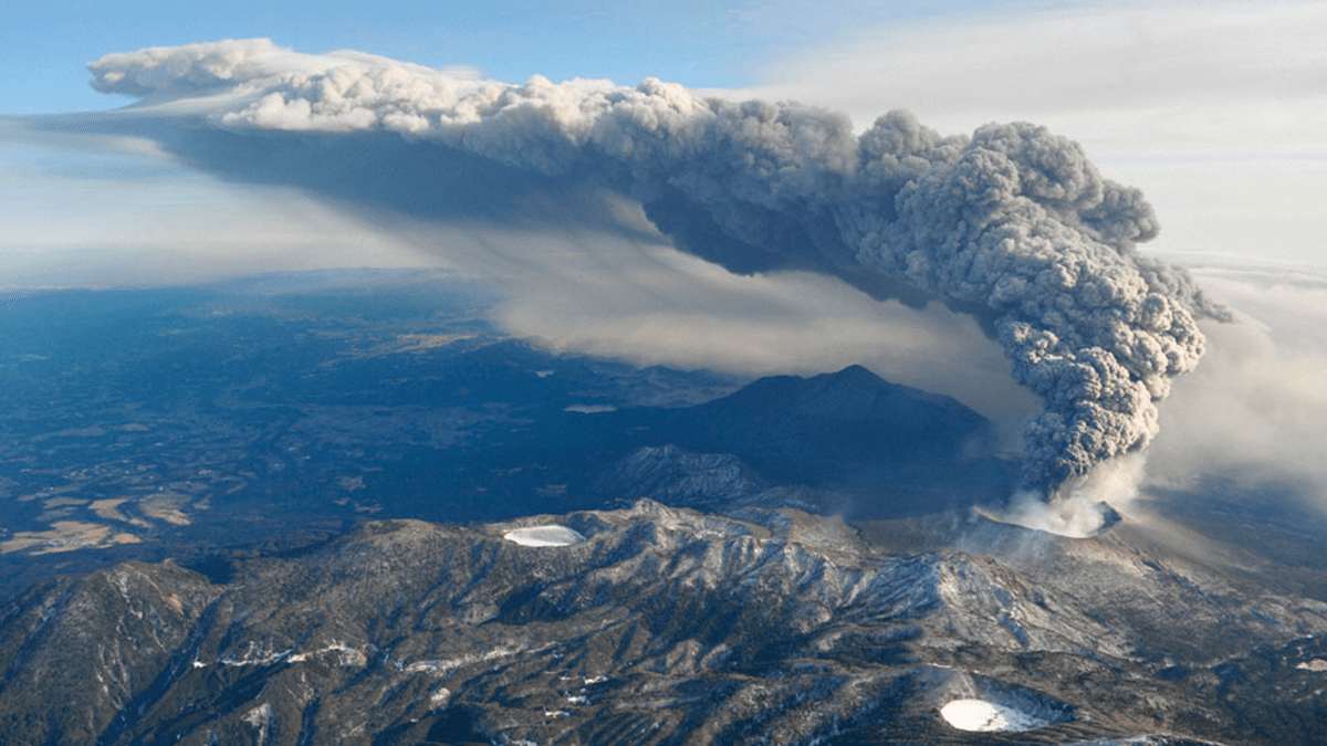 Photo of a large plume of smoke emitting from a volcano.